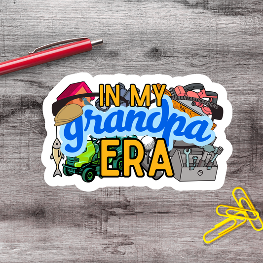 a sticker with the text "IN MY GRANDPA ERA" surrounded by various objects such as a pen, a stapler, and a pair of scissors.