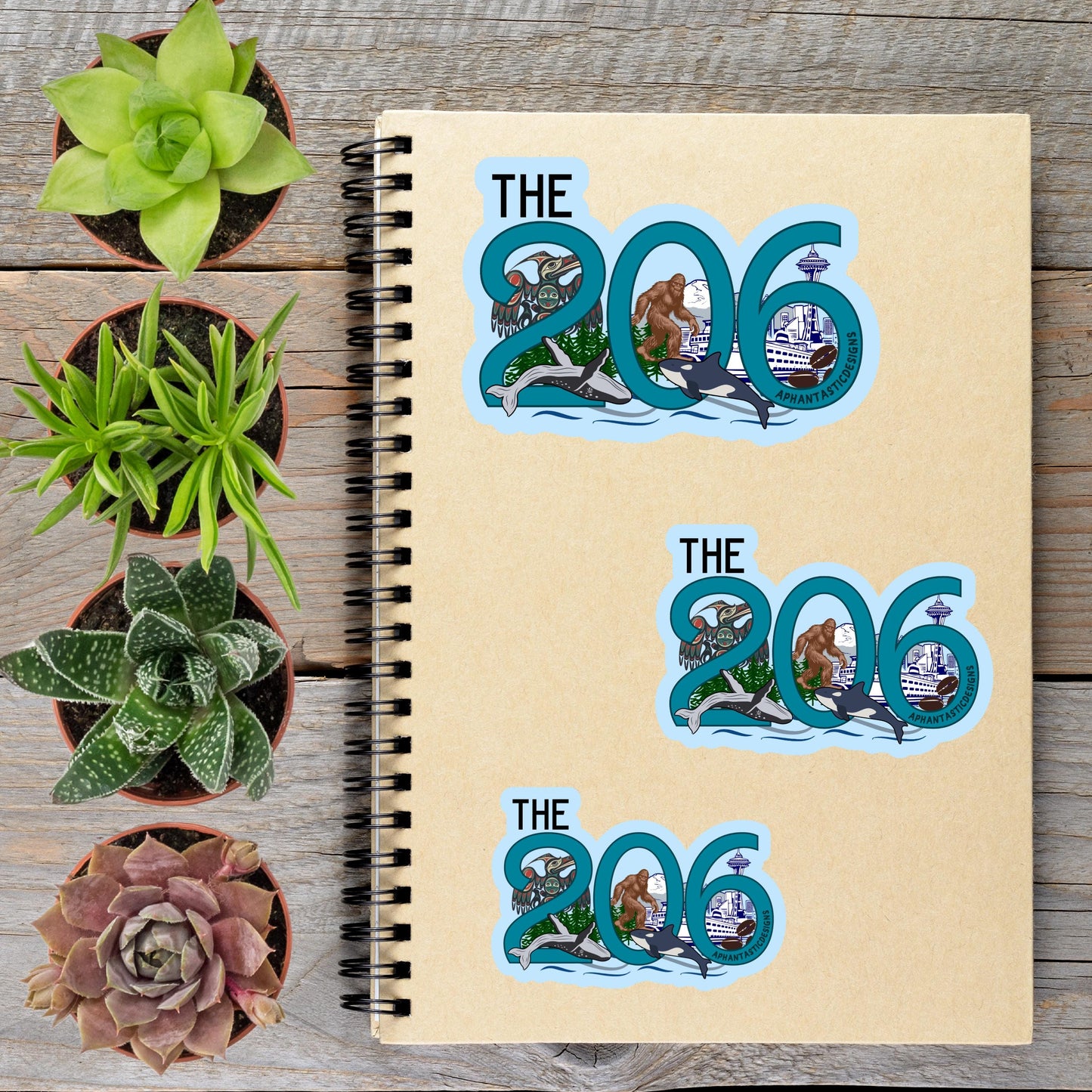 a spiral-bound notebook with three stickers on the cover, each depicting a different plant or succulent. The stickers are arranged in a way that they form the numbers '206' and '306', suggesting a connection to these numbers or a theme related to them.