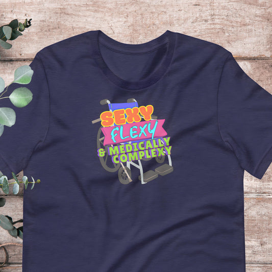 A navy blue t-shirt with a colorful graphic design featuring a wheelchair and the text "SEXY FLEXY & MEDICALLY COMPLEX".