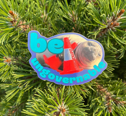 A sticker with the text "be ungovernable" and an image of a seal or seal-like creature.