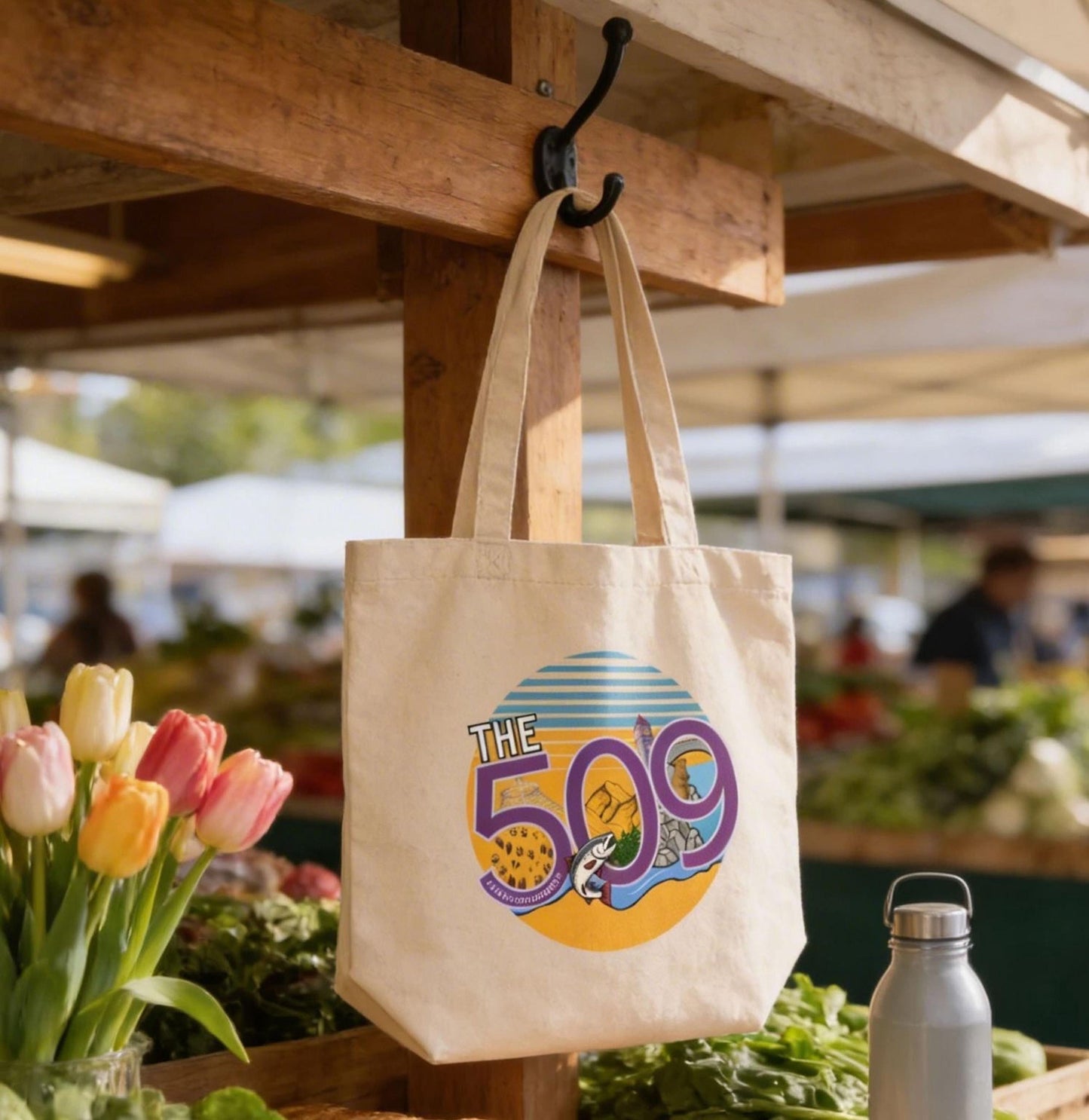 a wooden table with a white tote bag hanging from a hook, a loaf of bread, and a water bottle, all set against a backdrop of a bustling outdoor market.
