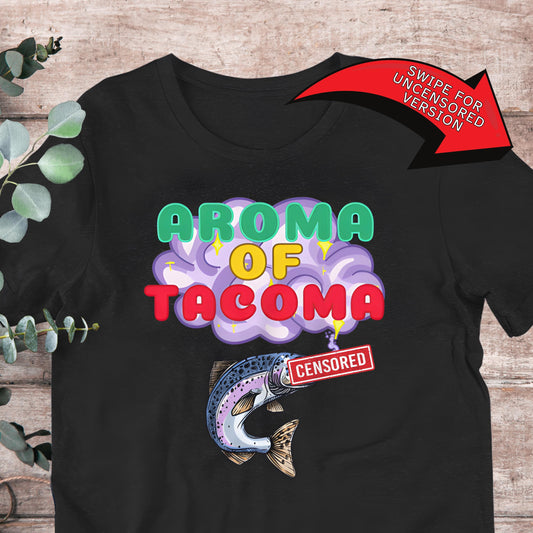 The image is a black t-shirt with a graphic design featuring a fish and the text "AROMA OF TACOMA" in a colorful, stylized font. There is also a red "CENSORED" sticker on the shirt.