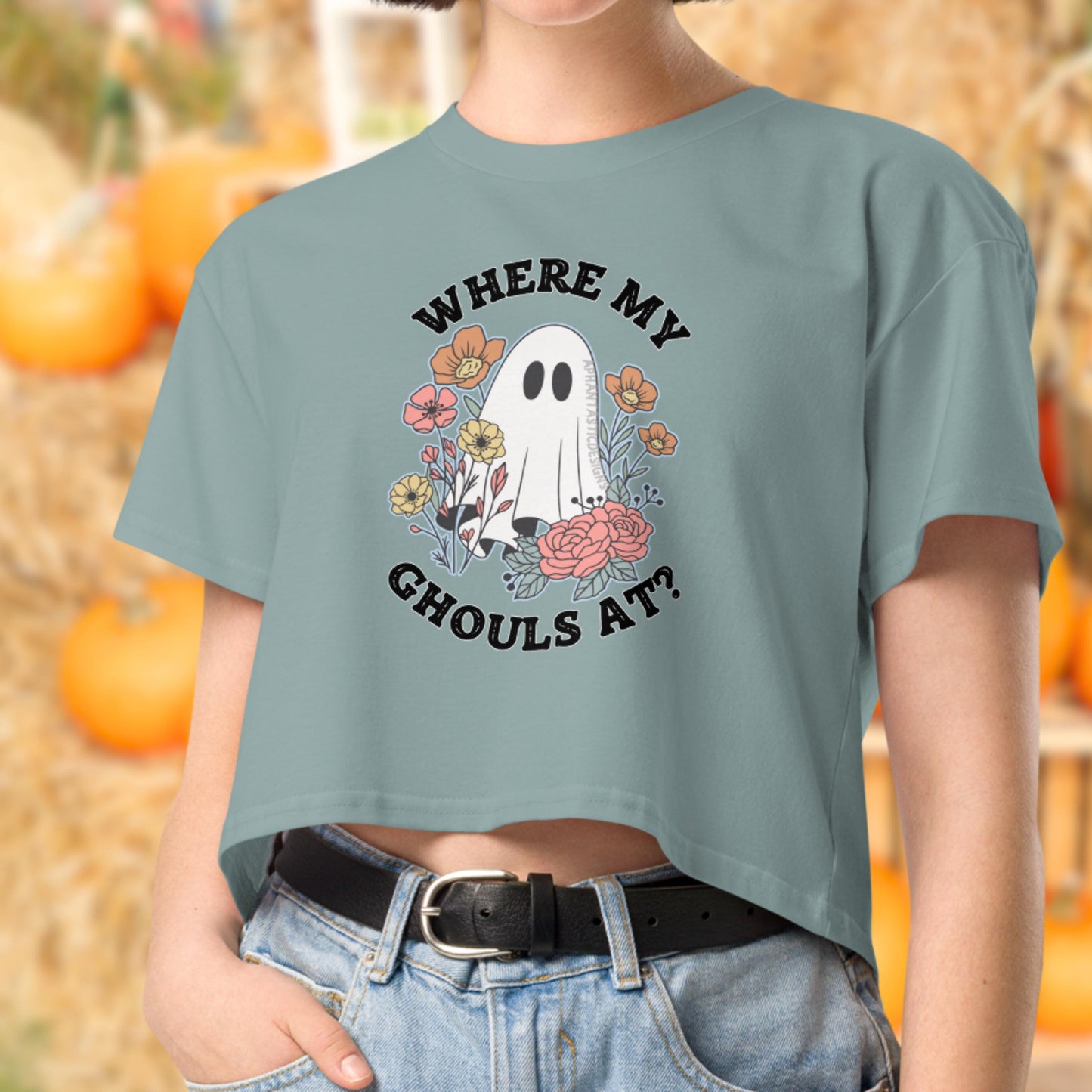 A person wearing a green t-shirt with a graphic design of a ghost surrounded by flowers and the text "WHERE MY GHOULS AT?"