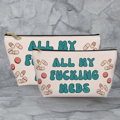 two white cosmetic bags with teal and pink text and illustrations of pills.