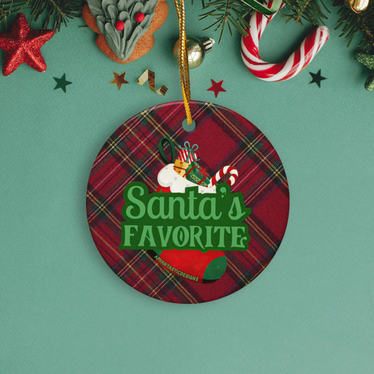 A Christmas ornament with a plaid pattern and the text "Santa's FAVORITE" is displayed on a green background.