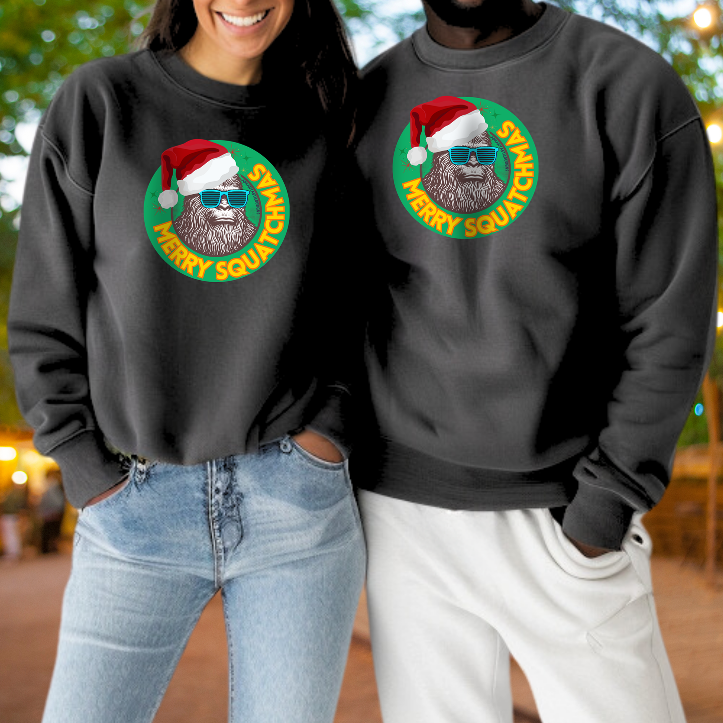 A woman and a man are standing together, both wearing black sweatshirts with a graphic of a Santa Claus beard and glasses.