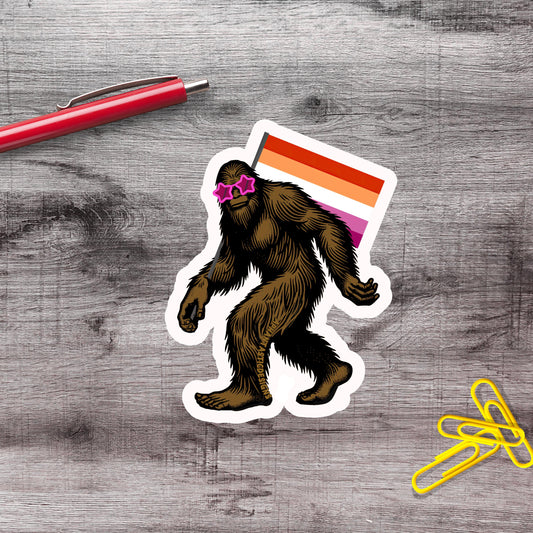 a sticker of a cartoon-like creature with a large head and long body, wearing sunglasses and carrying a flag.