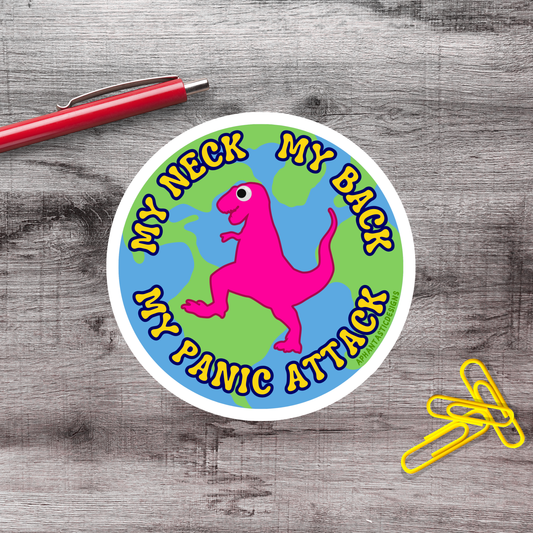 A sticker with a pink dinosaur and the text "My neck, my panic attack" is placed on a wooden surface next to a red pen and yellow paper clips.