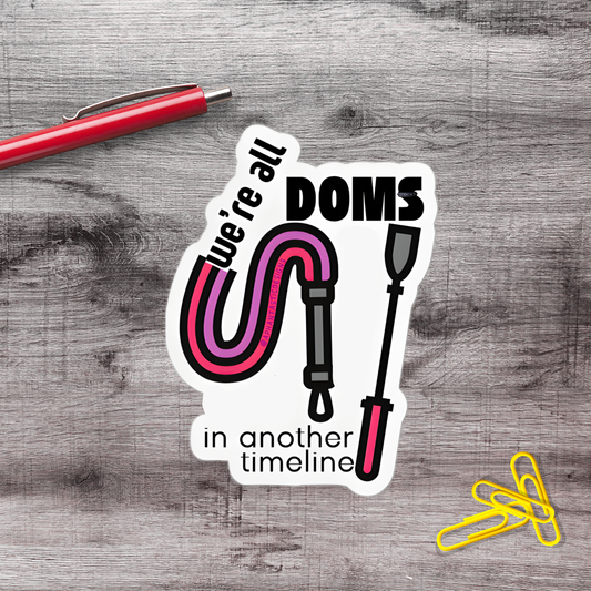 a sticker with a pink and purple design, accompanied by a red pen and a yellow stapler on a wooden surface.