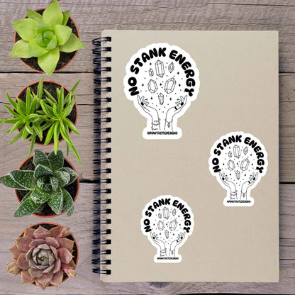 a notebook with stickers on it, along with several potted plants arranged on a wooden surface.