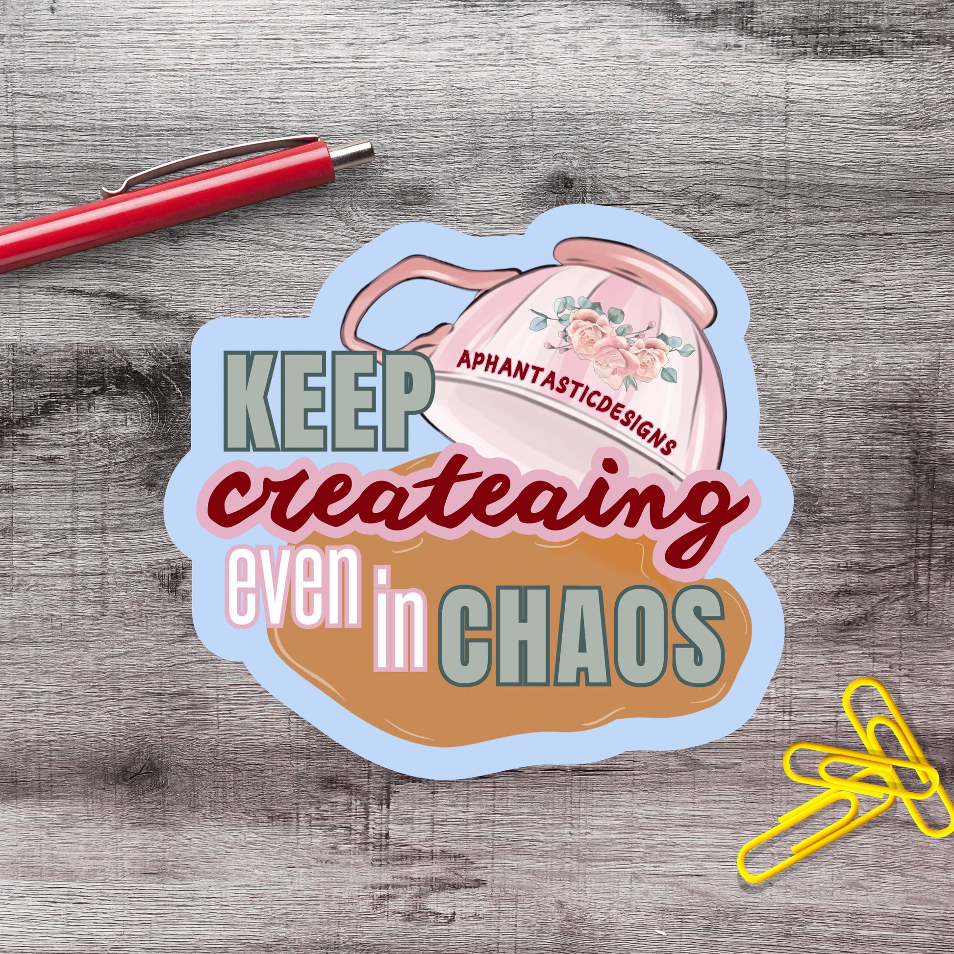 a sticker with the text "KEEP creating even in CHAOS" and an illustration of a teapot with flowers.