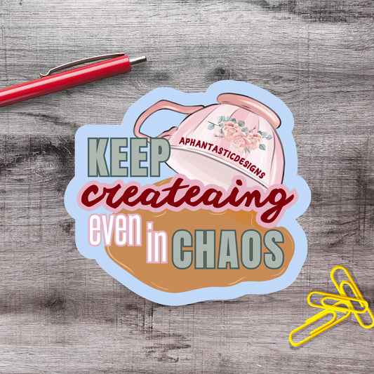 a sticker with the text "KEEP creating even in CHAOS" and an illustration of a teapot with flowers.