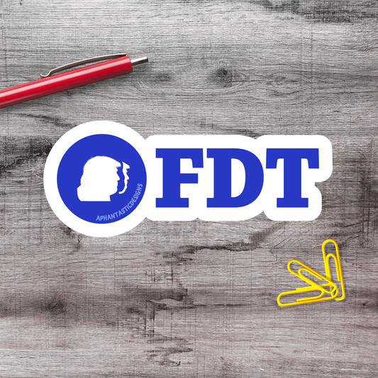 a wooden surface with a red pen, a blue and white sticker with the letters "FDT" in the center, and a pile of yellow paper clips.