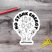 A sticker with a hand holding a crystal surrounded by stars, with the text "No Stank Energy" and "Aphantastic Designs" written on it.