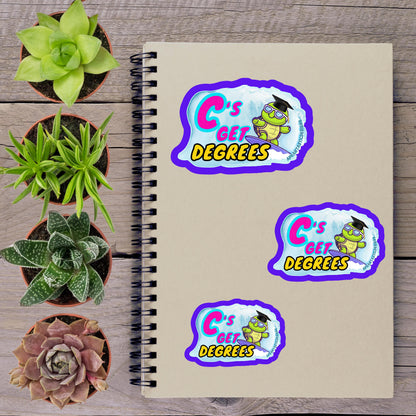 a spiral notebook with three stickers on it, along with several potted plants arranged on a wooden surface.