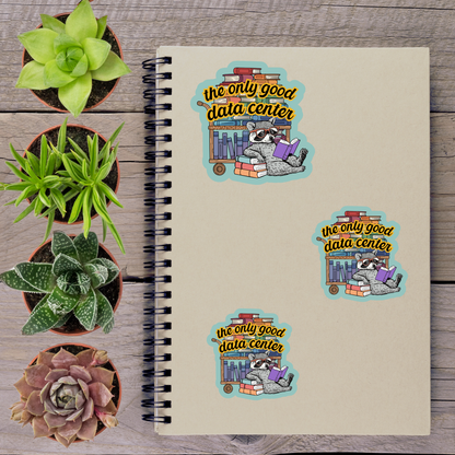 a spiral notebook with stickers on it, along with several potted plants arranged on a wooden surface.