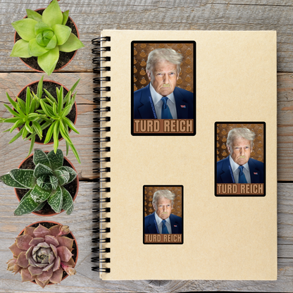 a spiral notebook with three stickers on it, each depicting a man wearing a suit and tie. The stickers are arranged on the notebook, and there are several potted plants placed around the notebook and stickers.