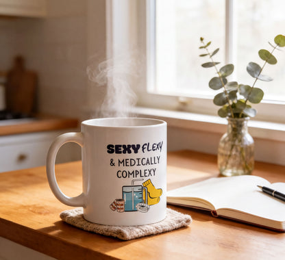 A white mug with a humorous text design sits on a wooden table, with steam rising from it. The mug is placed next to a notebook and a pen, suggesting a workspace or study area.