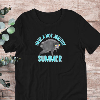A black t-shirt with a graphic design featuring a raccoon wearing sunglasses and the text "Have a hot jumbo summer" printed on it.