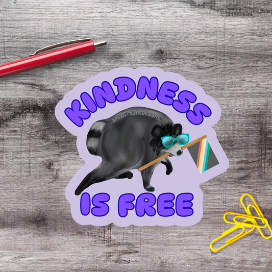a sticker with a raccoon holding a rainbow flag and the text "Kindness is free" written on it.