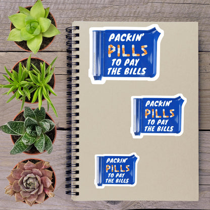 a spiral notebook with three stickers on it, along with four potted plants arranged on a wooden surface.