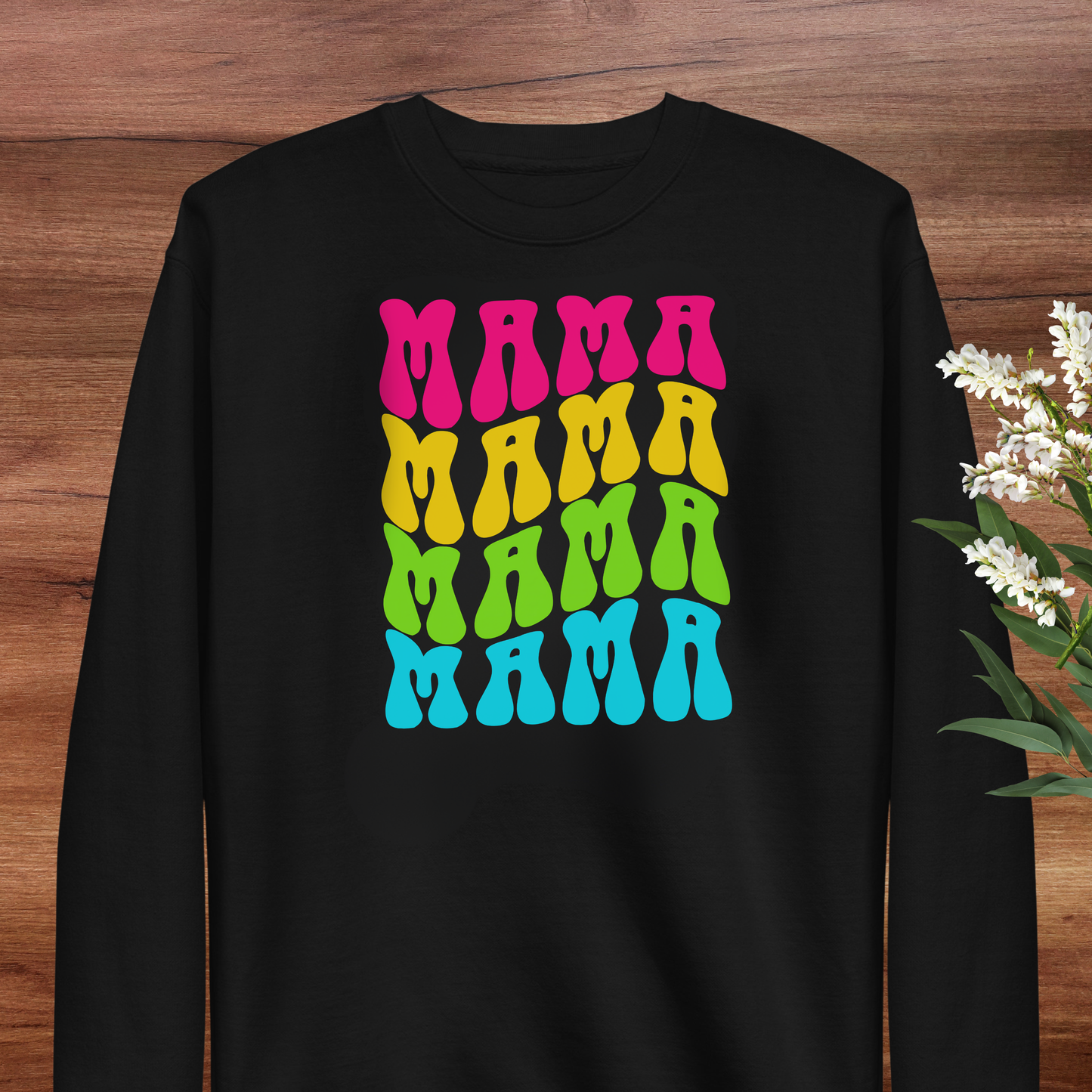 A black long-sleeved shirt with a colorful graphic design featuring the word "MAMA" repeated in a vibrant, retro-style font.
