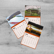three calendar pages, each with different photos and dates. The first page shows a kite, the second page depicts a park bench, and the third page features a train.