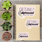 a notebook with stickers on it, surrounded by four potted plants.