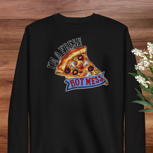 A black long-sleeved shirt with a graphic design depicting a slice of pizza with various toppings, accompanied by the text "I'm a fresh hot mess".