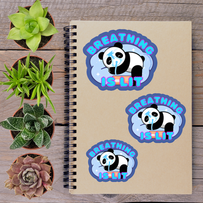 a spiral-bound notebook with three stickers on it, along with several potted plants arranged on a wooden surface.