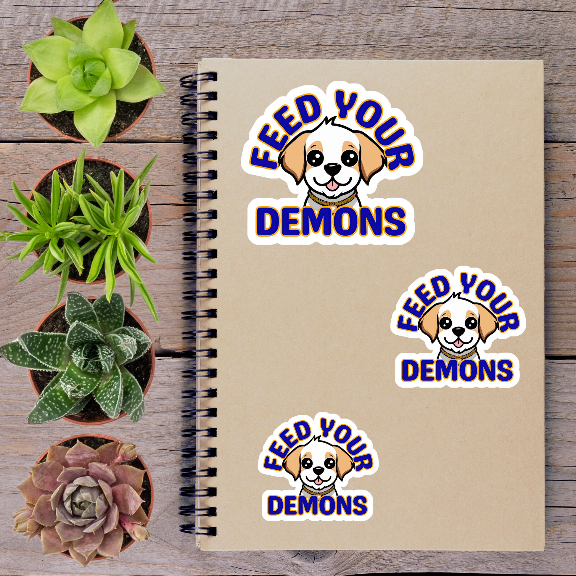 a notebook with stickers on it, surrounded by potted plants and a wooden surface.