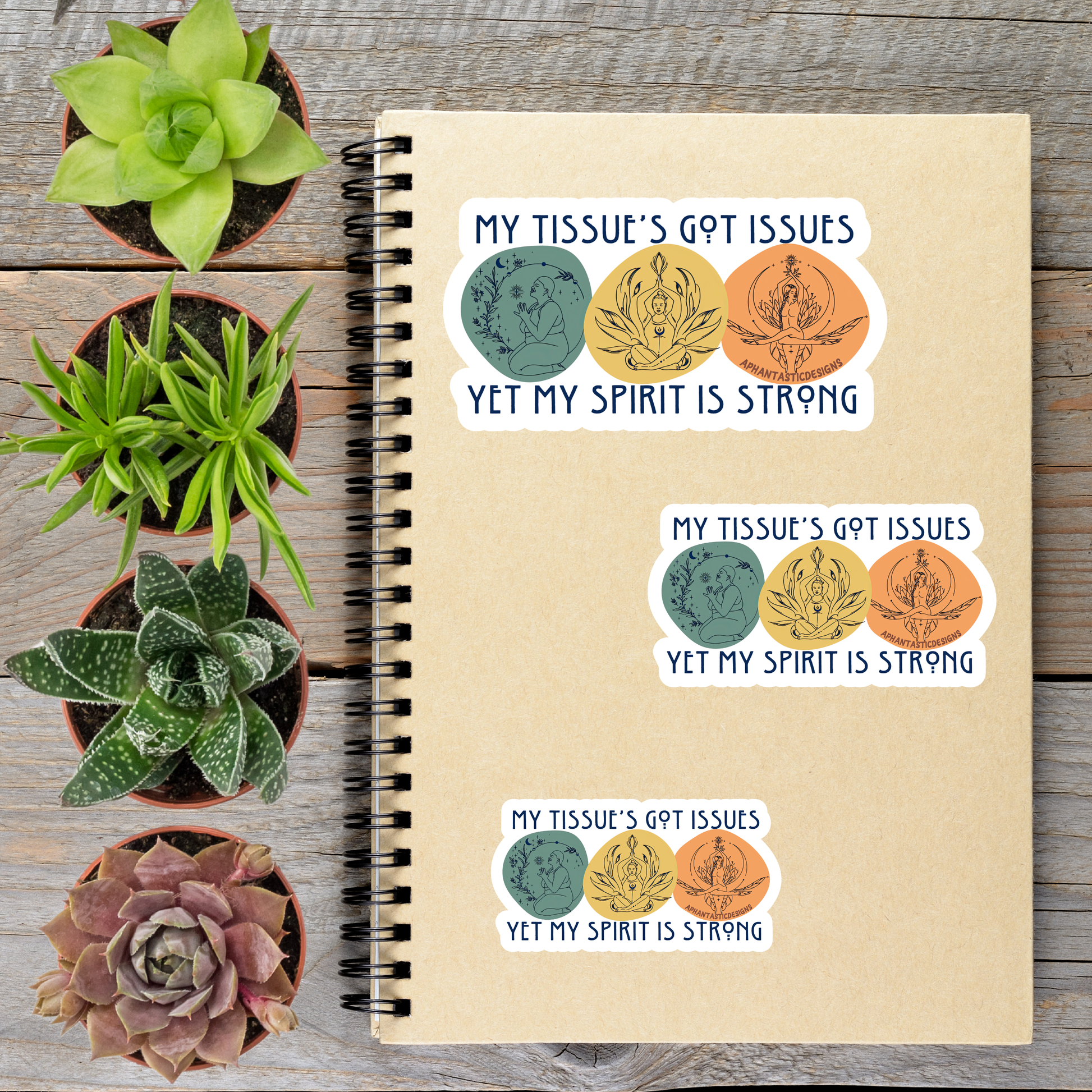 a notebook with stickers on it, along with four potted succulent plants arranged on a wooden surface.