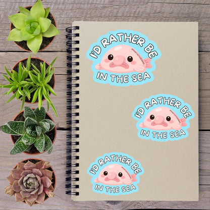 a notebook with stickers on it, along with several potted plants arranged on a wooden surface.