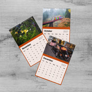 The image is a three-page calendar with various photographs, including a bridge, flowers, and a car. The calendar is set against a wooden background.