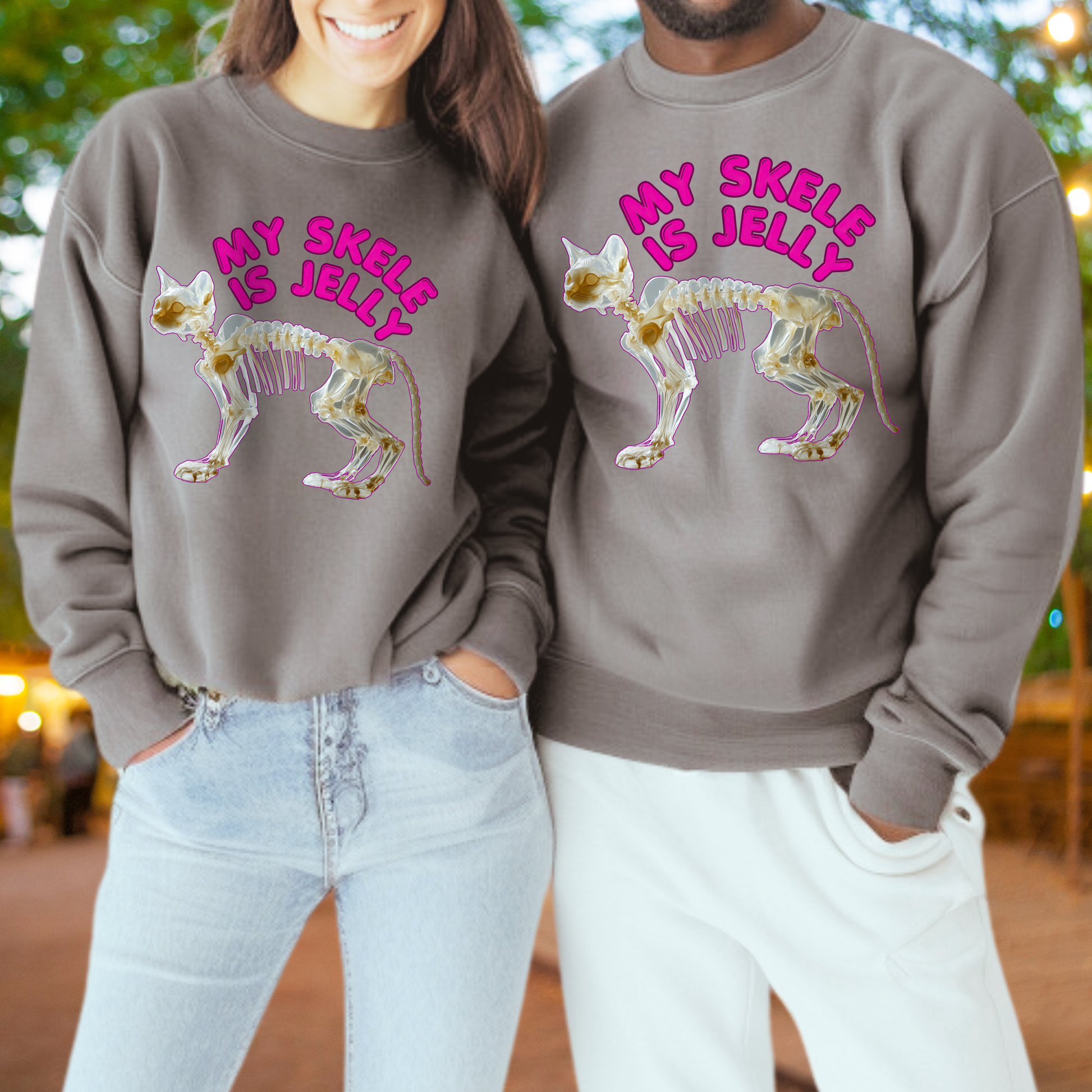 Two people wearing matching gray sweatshirts with a cat skeleton design and text printed on them.