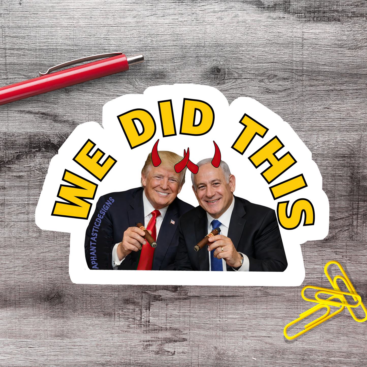 A sticker featuring two men in suits, one wearing a red tie and the other wearing a blue tie, with horns on their heads, and the text "WE DID THIS" prominently displayed.