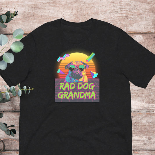 A black t-shirt with a graphic design featuring a pug dog wearing sunglasses and the text "RAD DOG GRANDMA" against a colorful background.