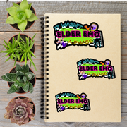a spiral notebook with three stickers on it, along with four potted plants arranged on a wooden surface.