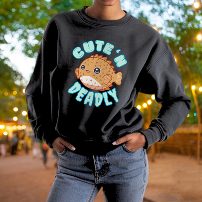 A person wearing a black sweatshirt with a graphic of a fish and the text "CUTE 'N DEADLY" printed on it.