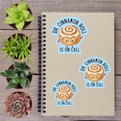 a notebook with stickers on it, along with several potted plants arranged on a wooden surface.