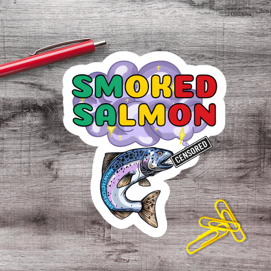 a sticker with the text "SMOKED SALMON" and an illustration of a fish. There is also a red pen and some yellow paper clips on a wooden surface.