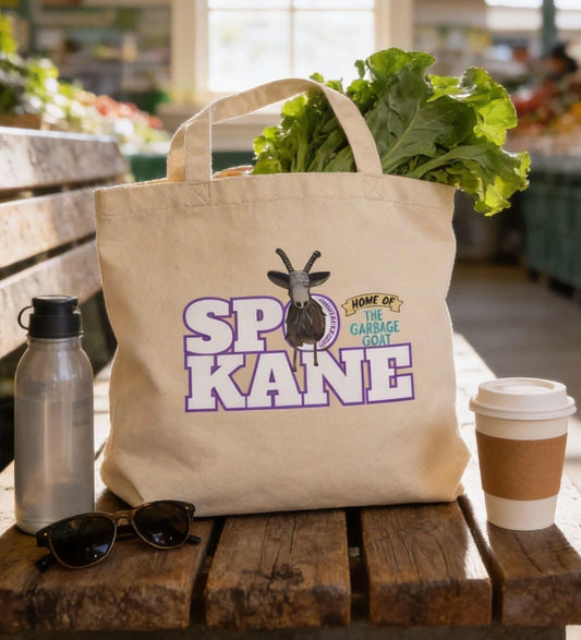 A beige tote bag with a graphic design, a water bottle, sunglasses, and a coffee cup are placed on a wooden bench in a grocery store.