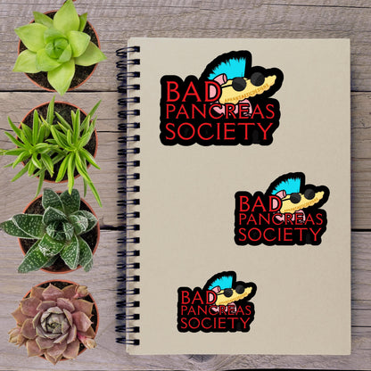 a spiral notebook with stickers on it, along with several potted plants arranged on a wooden surface.