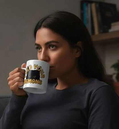 A woman sits on a couch, reading a book and sipping a beverage, with a lit candle on a small table in front of her.