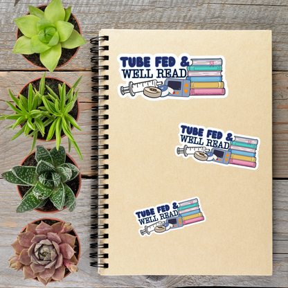 a spiral notebook with stickers on it, along with four potted plants arranged on a wooden surface.