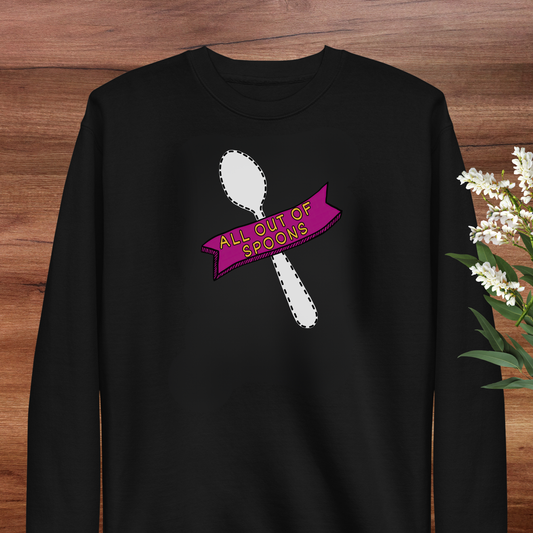 A black long-sleeved shirt with a graphic design on it, featuring a white spoon and a pink banner with the text "All our spoons".