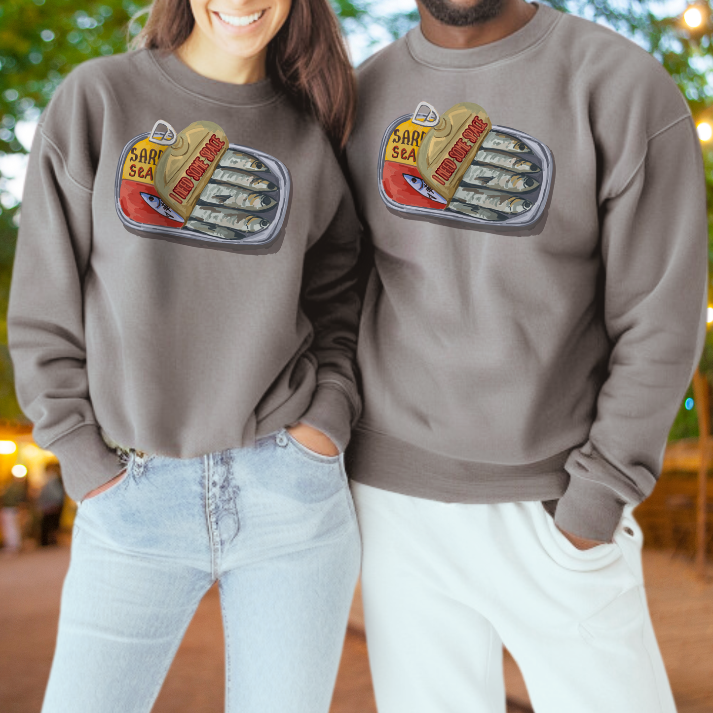 Two people wearing matching gray sweatshirts with a graphic of a can of sardines.
